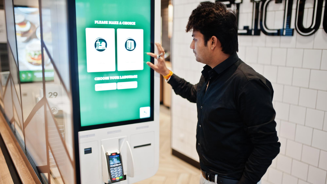 Man using Self checkout kiosk for shopping